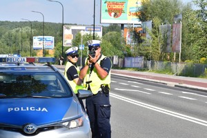 zdjęcie kolorowe: policjant kontrolujący prędkość w rejonie przejścia dla pieszych