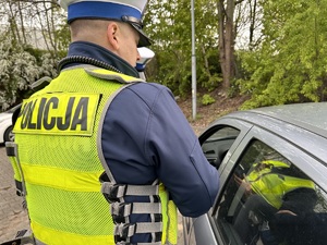 zdjęcie kolorowe: policjant katowickiej drogówki podczas kontroli samochodu osobowego