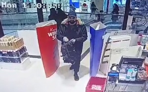 zdjęcie kolorowe: mężczyzna ubrany w zimową kurtkę, czapkę z daszkiem i zarostem na twarzy wchodzi do sklepu