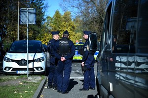 Zdjęcie przedstawia trzech policjantów oraz biały pojazd osobowy