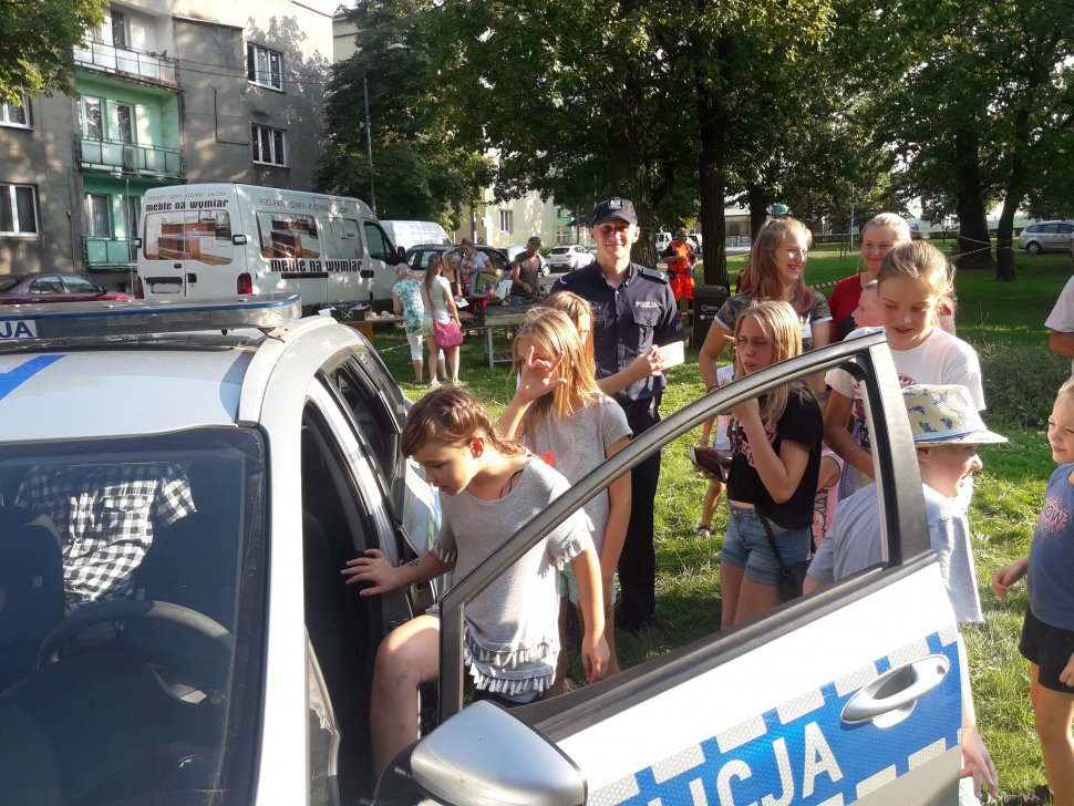 Zdjęcie kolorowe: dzielnicowy z Szopienic podczas spotkania z mieszkańcami dzielnicy w czasie Festyny Rodzinnego