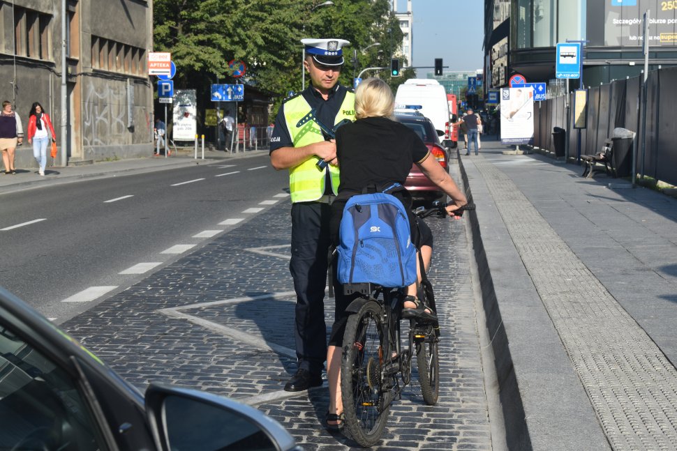 zdjęcie kolorowe: policjanci katowickiej drogówki podczas ogólnopolskich działań "NURD" w czasie kontroli rowerzystki