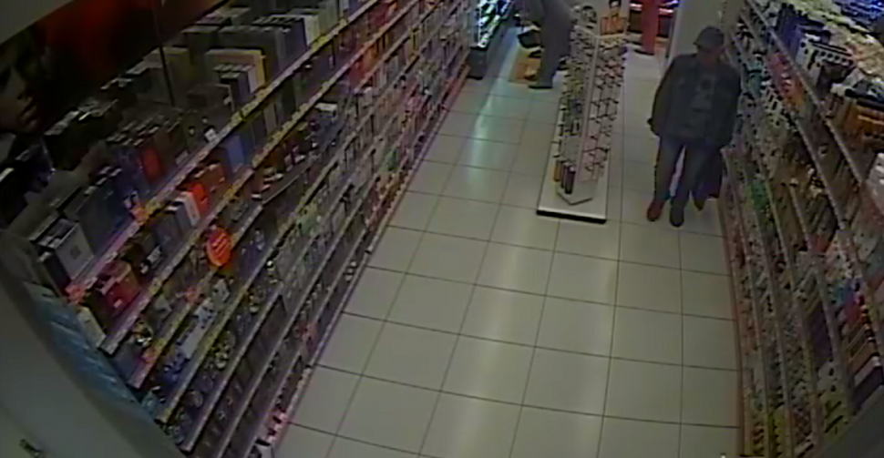 zdjęcie kolorowe: zapis z monitoringu sklepowego - starszy mężczyzna podejrzewany  kradzież perfum