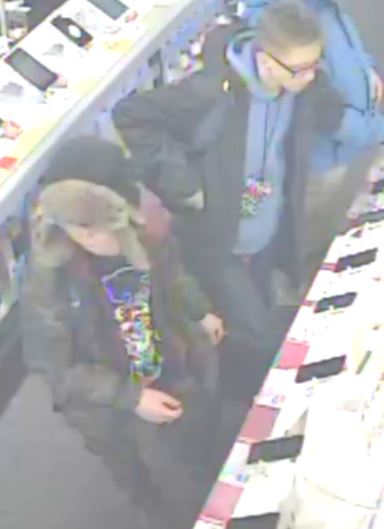 zdjęcie kolorowe z monitoringu: dwóch młodych mężczyzn podejrzanych o kradzież zegarka typu smartwatch