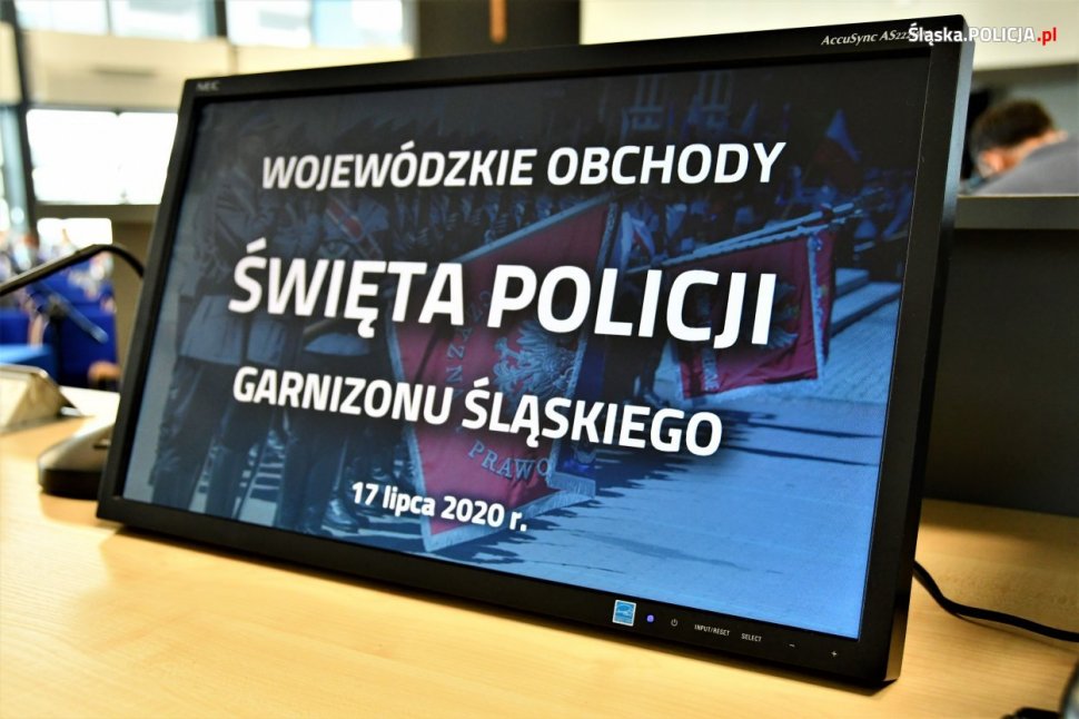 Zdjęcie kolorowe: ekran monitora z napisem Wojewódzkie Obchody Święta Policji garnizonu Śląskiego
