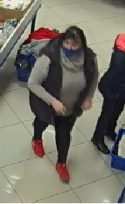 zdjęcie kolorowe: otyła kobieta podejrzewana o kradzież torebki, ubrana w szary długi sweter z golfem, ciemna kamizelkę, ciemne spodnie i czerwone sportowe buty i w czarnej maseczce ochronnej na twarzy