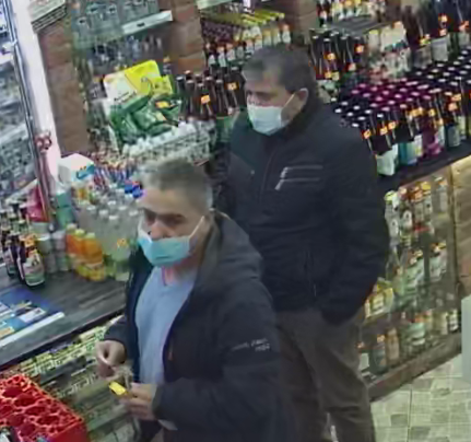 zdjęcie kolorowe: dwóch mężczyzn podejrzewanych o oszukanie ekspedientki stojących w sklepie