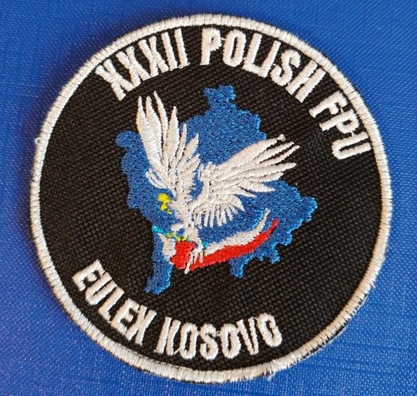 zdjęcie kolorowe: okolicznościowa naszywka na mundur przedstawiająca XXXII rotacji JSPP w Kosowie