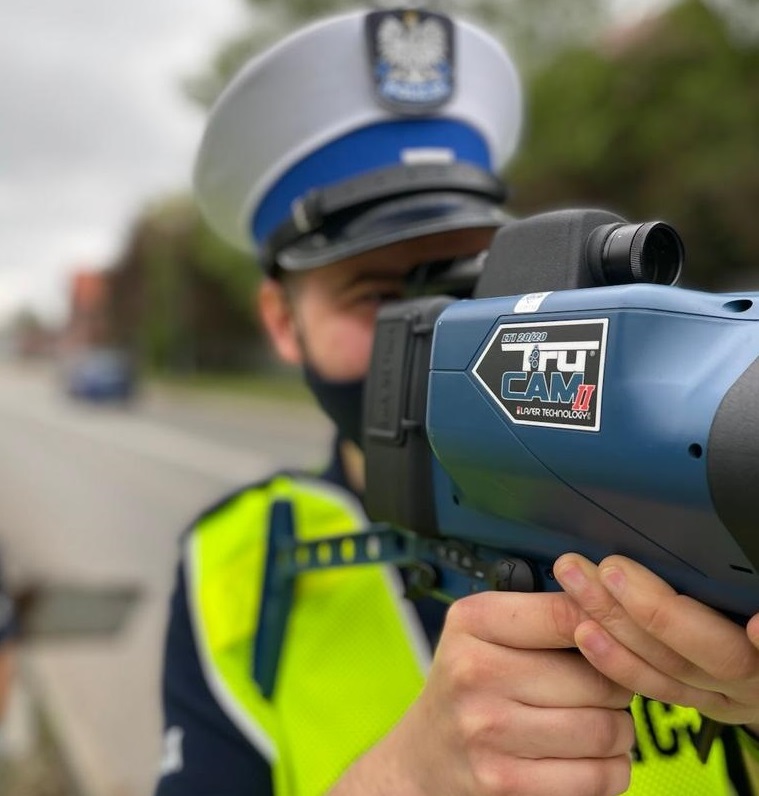 zdjęcie kolorowe: policjant katowickiej drogówki dokonujący pomiaru prędkości pojazdu