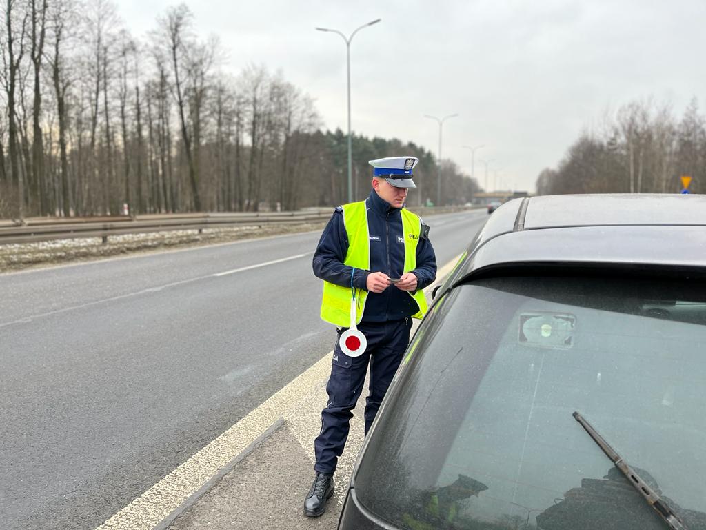 zdjęcie kolorowe: policjant katowickiej drogówki przeprowadzjący kontrolę drogową
