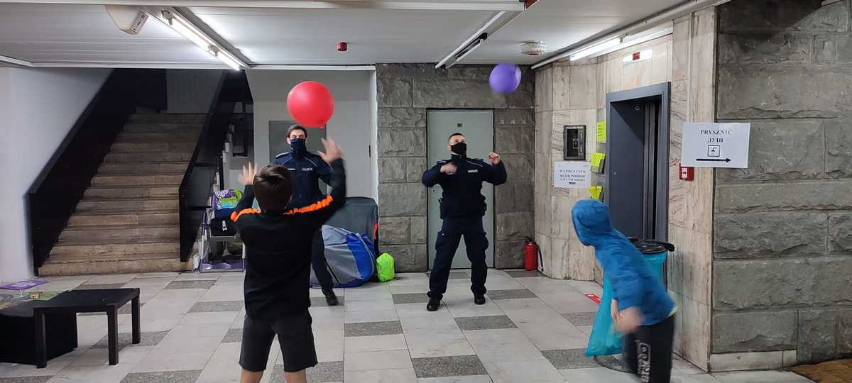 zdjęcie kolorowe: policjanci grający balonami z dziećmi