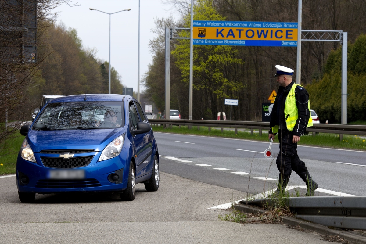 zdjęcie kolorowe: policjant katowickiej drogówki zatrzymujący pojazd do kontroli drogowej