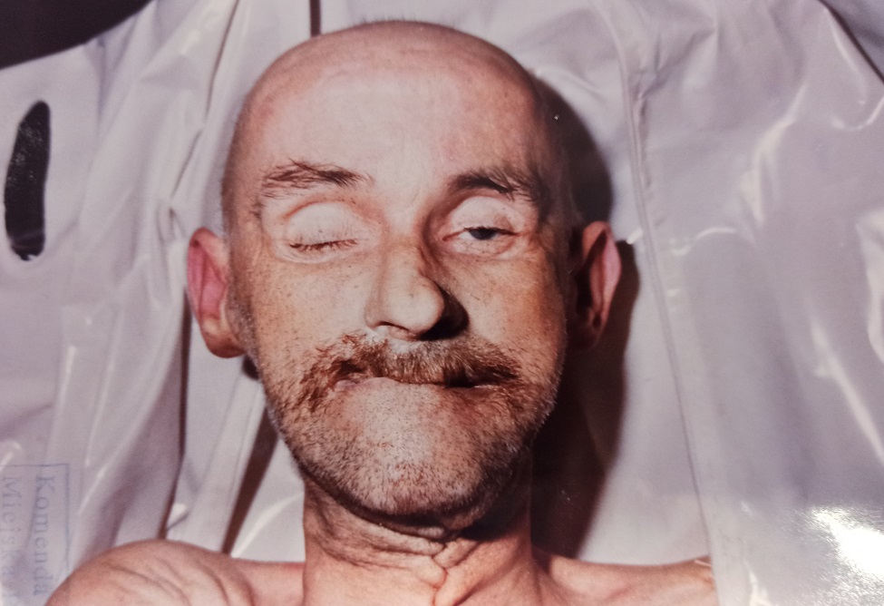 zdjęcie kolorowe: twarz zmarłego łysego mężczyzny z wąsem 