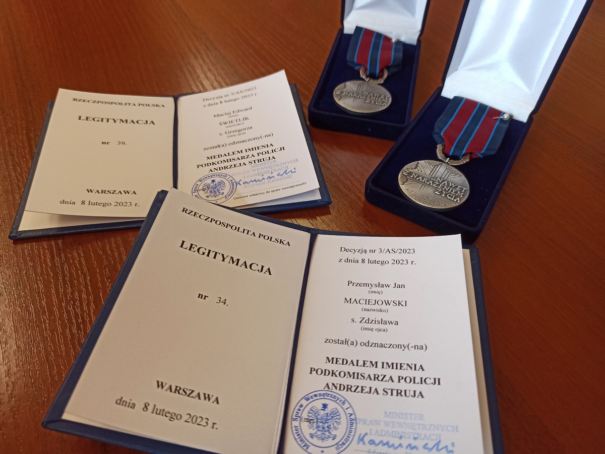  zdjęcie kolorowe: dwie legitymacje i dwa medale którymi odznaczeni zostali katowiccy policjanci