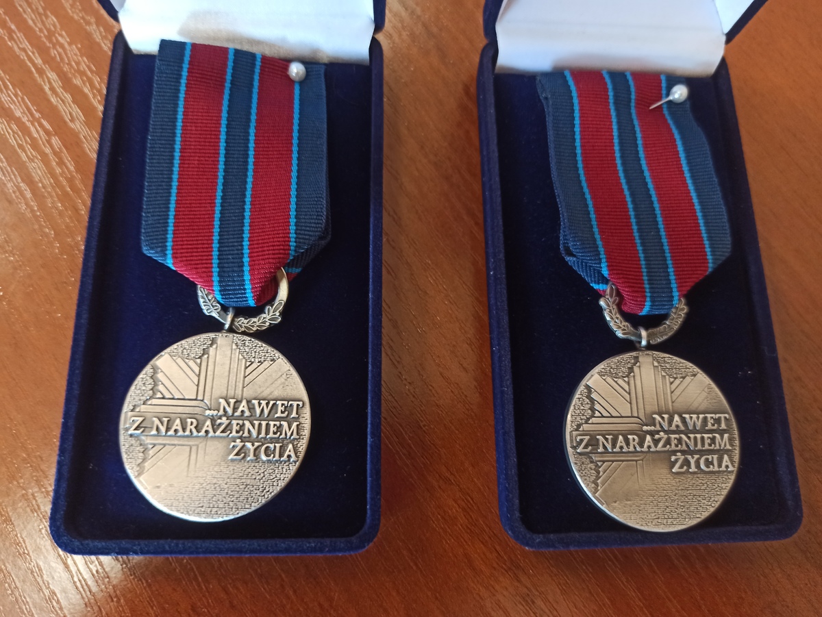 zdjęcie kolorowe: dwa medale którymi zostali odznaczeni katowiccy policjanci