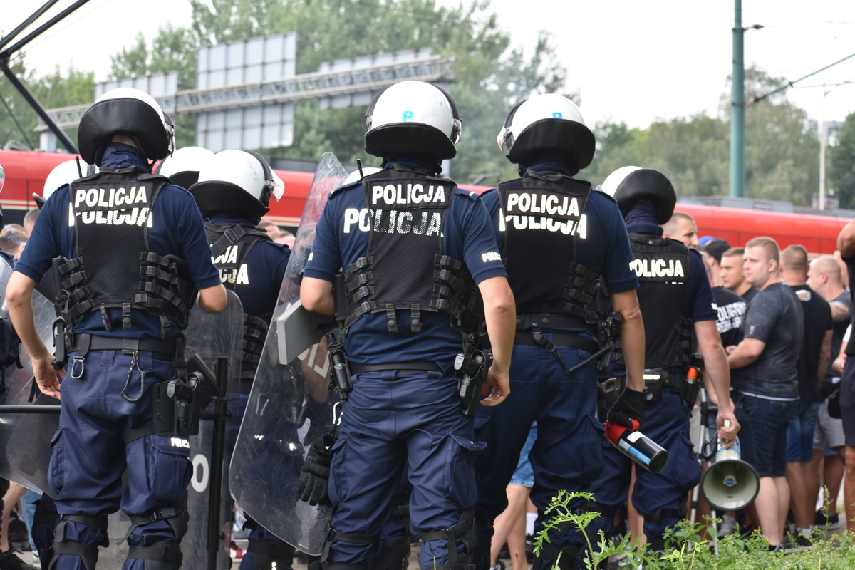 zdjęcie kolorowe: policjanci zabezpieczający przemarsz kibiców
