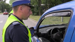 Policjant w trakcie kontroli drogowej samochodu