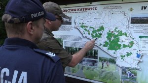Funkcjonriusz Straży Leśnej pokazuje na mapie trasy nielegalnych rajdów quadowców i motocyklistów