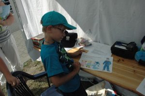 Chłopiec prezentuje pokolorowany przez siebie obrazek