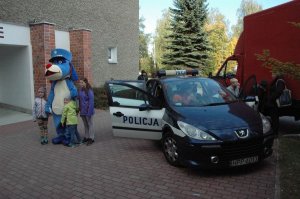 Sznupek w towarzystwie dzieci oraz dzieci oglądające policyjny radiowóz