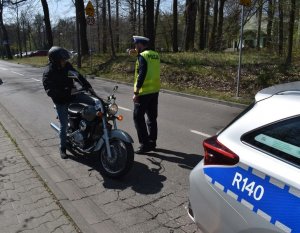 policjant podchodzi do motocyklisty który schodzi z motoru