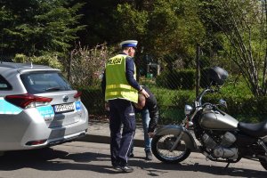 policjant z kierującym patrzą na motocykl