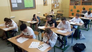 Na zdjęciu widać uczniów siedzących i piszących egzamin