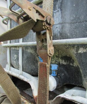 zdjęcie kolorowe: pojemnik typu mauser zapięty uszkodzonym pasem transportowym