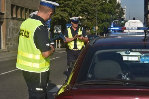 zdjęcie kolorowe: policjanci katowickiej drogówki podczas ogólnopolskich działań &quot;NURD&quot; w czasie kontroli pojazdu