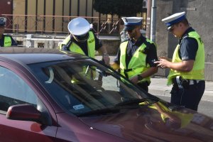 zdjęcie kolorowe: policjanci katowickiej drogówki podczas ogólnopolskich działań &quot;NURD&quot; w czasie kontroli pojazdu