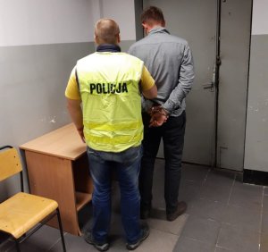 zdjęcie kolorowe: policjant katowickiego oddziału prewencji z zatrzymanym mężczyzną podejrzanym o chęć nawiązania kontaktu seksualnego z osobą poniżej 15 roku życia