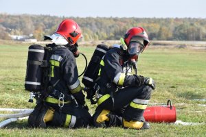 zdjęcie kolorowe: dwóch strażaków podczas akcji ratowniczej
