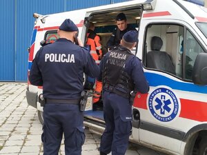 zdjęcie kolorowe: katowiccy policjanci przy karetce pogotowia