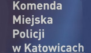 zdjęcie kolorowe: na granatowym tle biały napis Komenda Miejska Policji w Katowicach