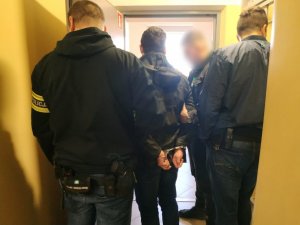 zdjęcie kolorowe: policjanci katowickiej komendy z mężczyzną podejrzanym o oszustwa