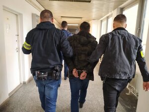 zdjęcie kolorowe: policjanci katowickiej komendy z mężczyzną podejrzanym o oszustwa