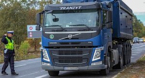 zdjęcie kolorowe: policjant ruchu drogowego podczas kontroli ciężarówki