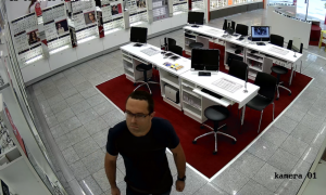 zdjęcie kolorowe: mężczyzna podejrzewany o kradzież oprawek okularów w salonie optycznym, zarejestrowany przez sklepowy monitoring