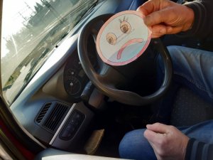 Na kolorowym zdjęciu widać rękę kierowcy trzymającego laurkę