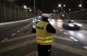 zdjęcie kolorowe: policjant katowickiej drogówki podczas kontroli prędkości pojazdu w ramach działań &quot;Prędkość&quot;
