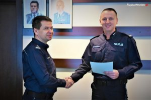 Na zdjęciu widać dwóch oficerów policji stojących w sali odpraw Komendy Wojewódzkiej Policji w Katowicach