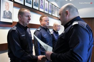 Na zdjęciu widać czterech oficerów policji stojących w sali odpraw Komendy Wojewódzkiej Policji w Katowicach