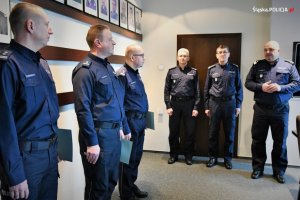 Na zdjęciu widać sześciu oficerów policji stojących w sali odpraw Komendy Wojewódzkiej Policji w Katowicach