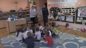 Na zdjęciu widać pracownika ZTM i policjantkę oraz dzieci w przedszkolu