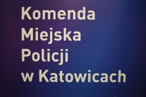 zdjęcie kolorowe: na granatowym tle napis komenda Miejska Policji w Katowicach