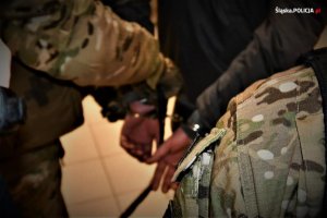 zdjęcie kolorowe: policyjni kontrterroryści zakładający kajdanki zatrzymanemu