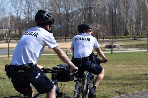 zdjęcie kolorowe: katowiccy policjanci podczas patrolu rowerowego, kontrolują parki