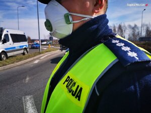 zdjęcie kolorowe: umundurowany policjant w maseczce
