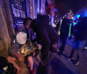 zdjęcie kolorowe: nieumundurowany policjant udzielający pomocy przedmedycznej