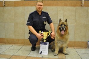 zdjęcie kolorowe: asp. szt. Łukasz Brzeziński z psem Korą - wyszkolonym do wyszukiwania zapachów narkotyków